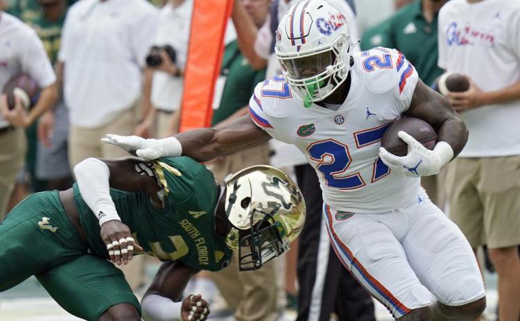 Florida running back Dameon Pierce gets past South Florida safety Vincent Davis on a run on Sept. 11 in Tampa. (CHRIS O'MEARA/Associated Press)