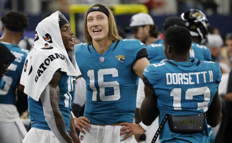 Jacksonville Jaguars' Laviska Shenault Jr., left, Trevor Lawrence (16) and Phillip Dorsett II (13) talk on the sideline during a preseason game against the Dallas Cowboys on Aug. 29, in Arlington, Texas. (MICHAEL AINSWORTH/Associated Press)