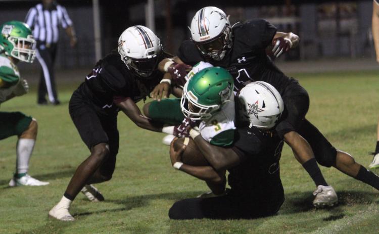 Suwannee running back Malachi Graham is tackled by a host of Madison County defenders on Friday. (PAUL BUCHANAN/Special to Reporter)