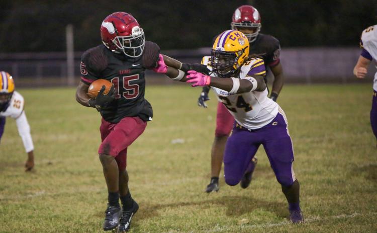 Raines’ Travis Laster stiff-arms Columbia linebacker Desavion Lee on Thursday. (BRENT KUYKENDALL/Lake City Reporter)