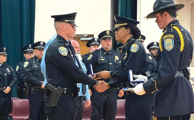 Lake City Police Officer Remington ‘Cody’ Chauncey (left) accepts his Police Purple Heart, presented by Police Chief Argatha Gilmore, on Monday. (COURTESY)