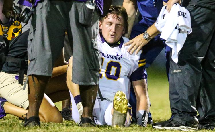 Columbia quarterback Kade Jackson is attended to by trainers after separating his shoulder during Friday’s game against Riverside. (GARY LLOYD MCCULLOUGH/Special to the Reporter)