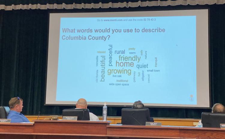 County Commissioners Tim Murphy (from left), Rocky Ford and Toby Witt look at a word cloud of residents’ descriptions of Columbia County. (JAMIE WACHTER/Lake City Reporter)