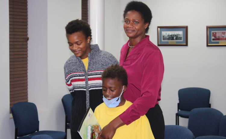 Befaithful Coker (right) stands with her two children, Victoria and Michael, in the council chambers. (TONY BRITT/Lake City Reporter)