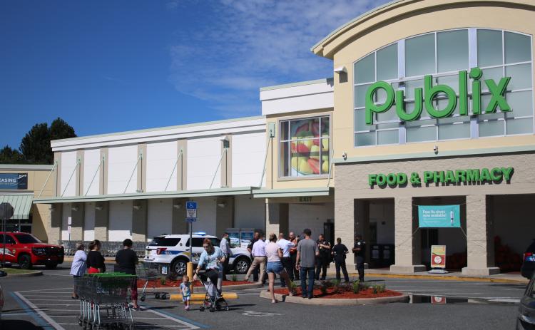 First responders hold potential customers outside at the Publix at 255 NW Commons Loop after a maintenance worker passed out and later died. (TONY BRITT/Lake City Reporter)