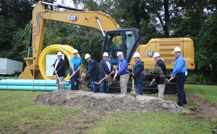 State and local officials Tom Kallemeyn (from left), Todd Sampson, Toby Witt, Rocky Ford, Stephen Witt, Tim Murphy, Dan Hartley and Hugh Thomas toss dirt during a ground breaking ceremony Wednesday for the State Road 47/I-75 Wastewater Improvements Project. (TONY BRITT/Lake City Reporter)