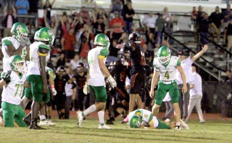 Suwannee kicker Braxtyn Green lays on the ground in dejection after his overtime field goal sailed wide left as Bishop Kenny players celebrate. (PAUL BUCHANAN/Special to the Reporter)