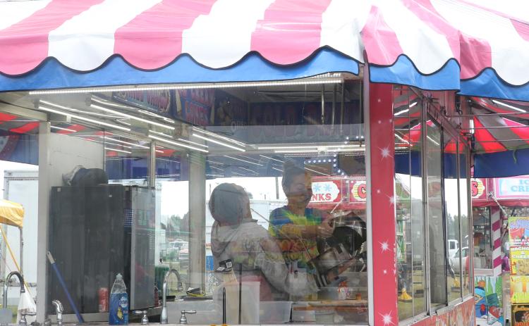 Hannah (left) and Faith Turner share a laugh as they set up a food trailer Thursday afternoon in preparation for opening night of the 67th annual Florida Gateway Fair. (MORGAN MCMULLEN/Lake City Reporter)