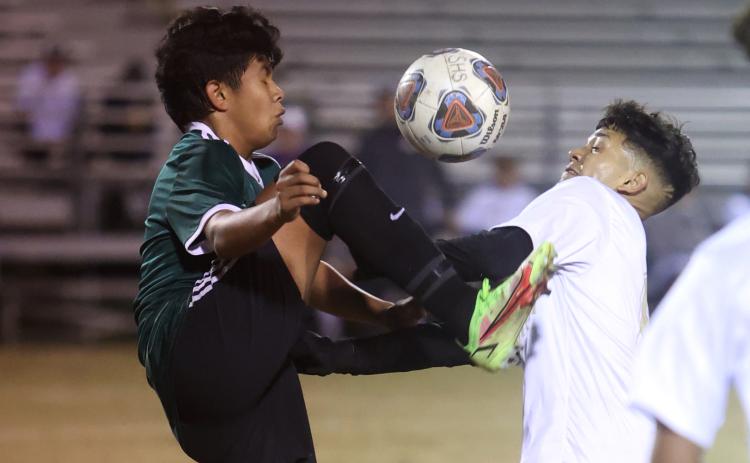 Columbia’s Noel Caballero (right) fights for possession of the ball with a Suwannee player on Tuesday night. (PAUL BUCHANAN/Special to the Reporter)