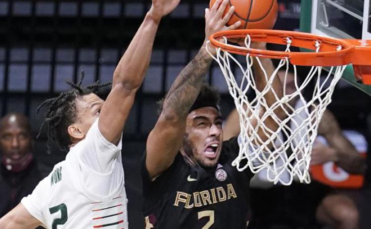 Florida State guard Anthony Polite drives to the basket as Miami guard Isaiah Wong defends on Feb. 24 in Coral Gables. (AP FILE)