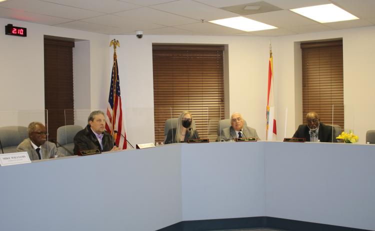 Members of the Lake City Council listen to a speaker at the podium during Monday's meeting. (TONY BRITT/Lake City Reporter)