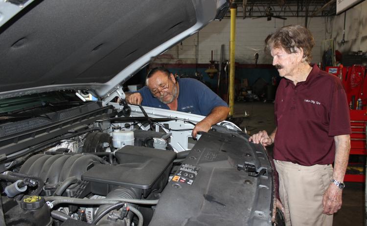 Lake City Tire Company owner Al Rollison (right) discusses an engine repair with lead technician Jim Givens  in the downtown auto repair shop in April 2020. (FILE)