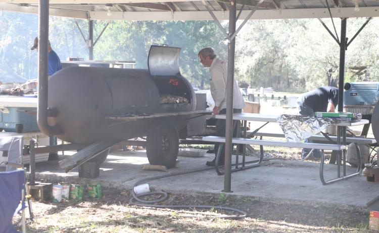 Pork is smoked at the Tustenuggee United Methodist Church on Wednesday, an annual pre-Thanksgiving tradition at the church for 63 years. (MORGAN MCMULLEN/Lake City Reporter)