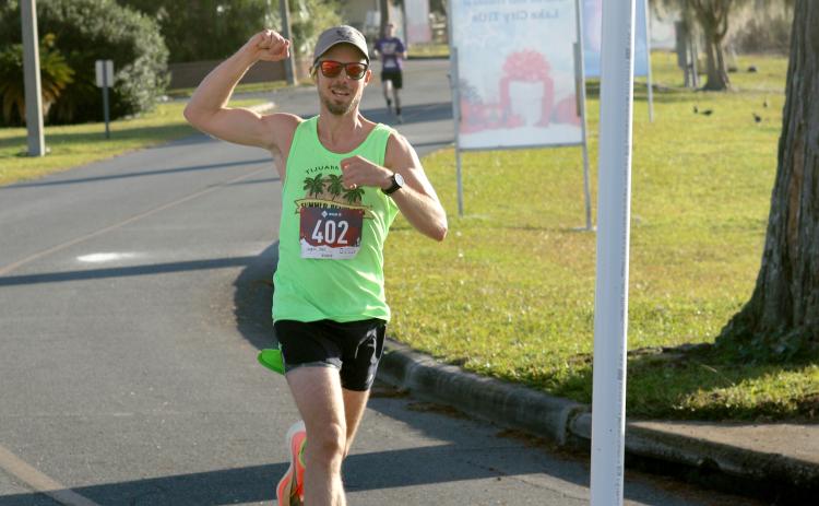 Peter Laughlin crosses the finish line to win the inaugural Turkey Trot 5K at Wilson Park in downtown Lake City on Thanksgiving morning. (JAMIE WACHTER/Lake City Reporter)