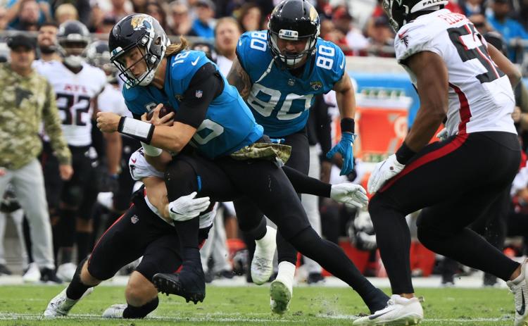 Jacksonville Jaguars quarterback Trevor Lawrence is tackled by Atlanta Falcons safety Erik Harris at TIAA Bank Field on Nov. 28 in Jacksonville. (COREY PERRINE/Florida Times-Union/TNS)