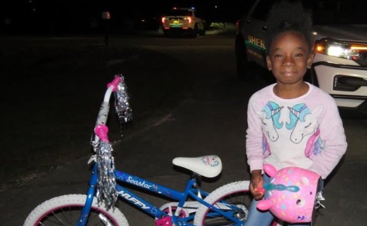 Jy’lar Fudge smiled Saturday night after receiving a new bicycle and a unicorn helmet from deputies with the Columbia County Sheriff’s Office. (COURTESY)