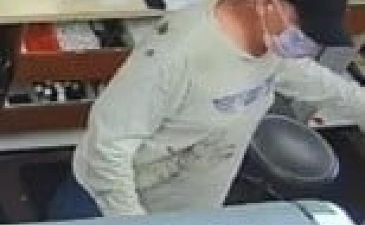 A security footage still from Baya Pharmacy shows the masked suspect. (COURTESY)