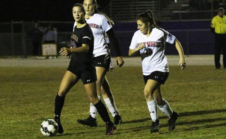 Columbia’s Skyler Ziegaus looks to pass as Fort White’s Riley Karlton chases her down Thursday night. (JORDAN KROEGER/Lake City Reporter)