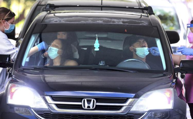 An Orange County family gets tested at the Econ Soccer Complex on the first day of the new covid-19 drive-thru testing site hosted by Orange County Health Services at the park off East Colonial Drive, in Orlando on Dec. 27. (JOE BURBANK/Associated Press)