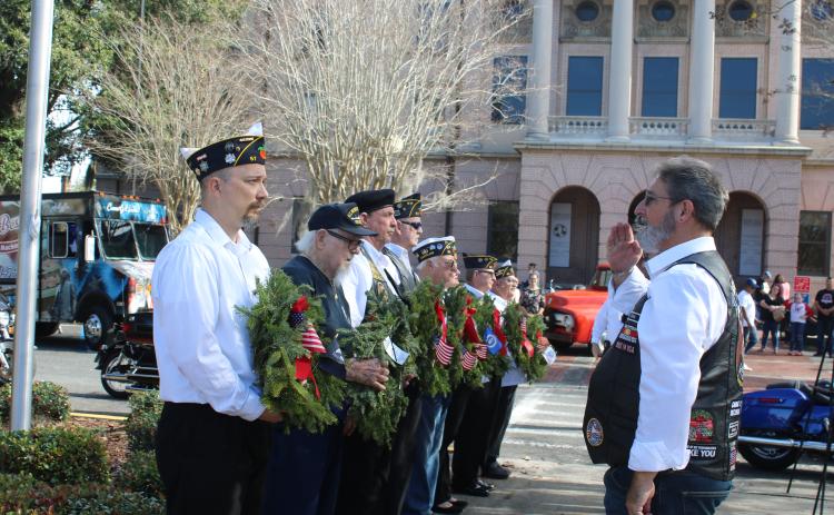 Mike Ziegler (left), holds a wreath for the POW/MIA memorial as he is saluted by Robert Mixon, during Saturday’s local Wreaths Across America event. (TONY BRITT/Lake City Reporter)