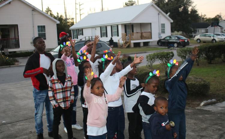 Children gather in the driveway of an Aberdeen home to sing Christmas carols on Wednesday afternoon. (TONY BRITT/Lake City Reporter)