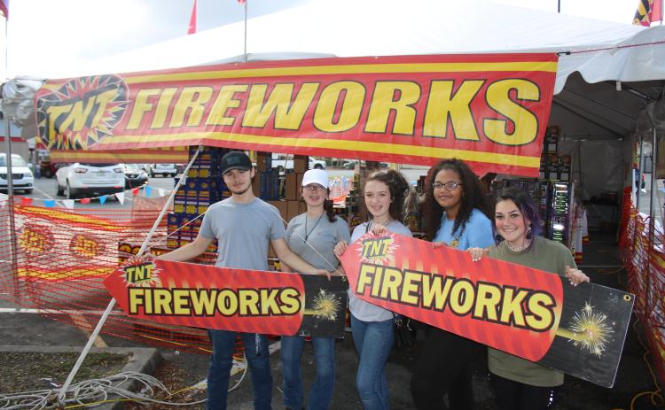 Columbia High School FFA students Logan Russ (from left), Kenzie Dungan, Kaylen Dungan, Cayden Hall and Emili Jones hold two TNT fireworks signs while promoting fireworks sales for the Columbia High School FFA fundraiser. (TONY BRITT/Lake City Reporter)