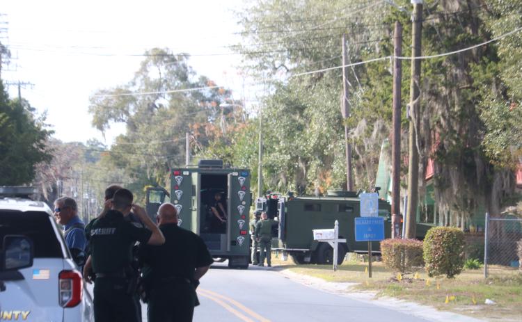 Members of the Columbia County Sheriff’s Office stand by as a pair of SWAT vehicles set up at the scene of a standoff Monday afternoon. (TONY BRITT/Lake City Reporter)