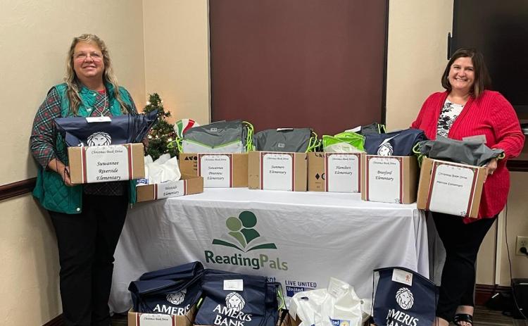 Donna MacRae (left) and Jennifer Lee, with United Way of Suwannee Valley Women United, hold and show boxes of books that go to local elementary school kindergartners during the Christmas break to help improve their literacy skills. (COURTESY)