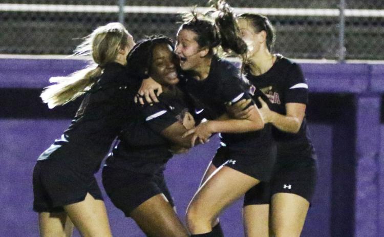 Columbia players celebrate with Olivia Kelly (middle left) after she scored a goal against Gainesville on Tuesday night. (MORGAN MCMULLEN/Lake City Reporter)