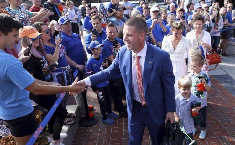 New Florida head coach Billy Napier shakes hands with fans as he and his family arrive at Ben Hill Griffin Stadium on Sunday in Gainesville. (BRAD MCCLENNY/The Gainesville Sun via AP)