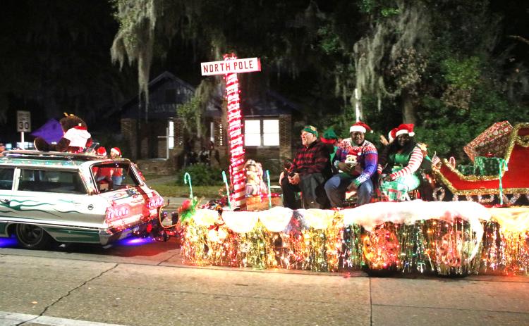 A parade float featuring Santa’s sleigh and a North Pole marker makes its way down Marion Avenue during the 2019 Christmas parade in Lake City. (FILE)