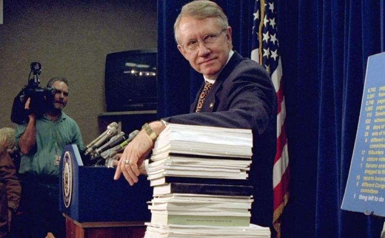 Sen. Harry Reid, D-Nev., leans on a stack of documents pertaining to campaign finance reform during a Capitol Hill news conference on Dec. 3, 1996, where the Democratic leadership for the 105th Congress was announced. (DENNIS COOK/Associated Press)