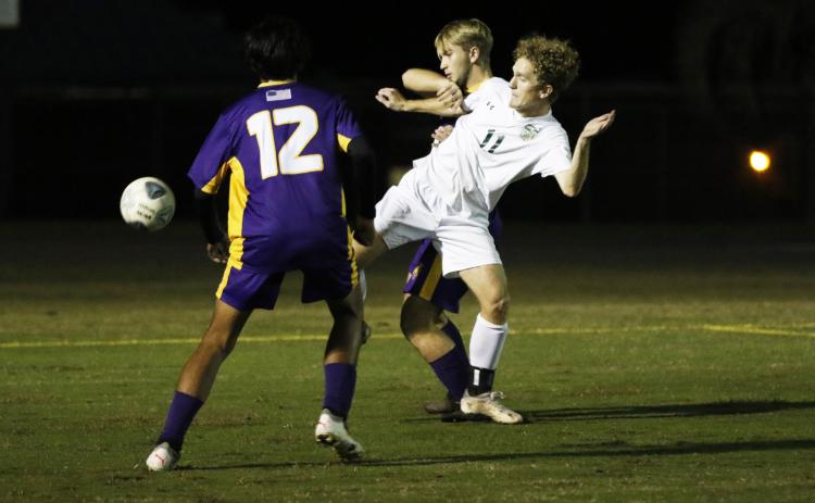 Columbia’s Jakob North (middle) and Lincoln’s Kyle Spratt fight for possession of the ball as Columbia’s Eduardo Morales rushes in during Monday night’s match. (JORDAN KROEGER/Lake City Reporter)