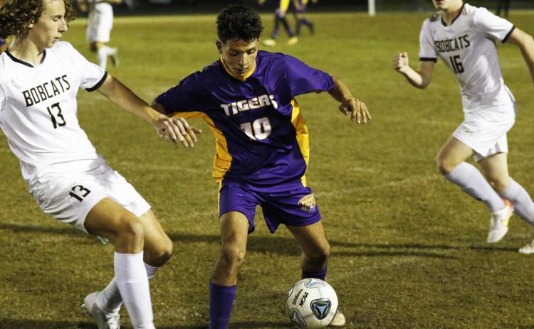Jason Caballero gathers possession of the ball as Buchholz’s Eduardo Santos rushes in to defend on Friday night. (JORDAN KROEGER/Lake City Reporter)