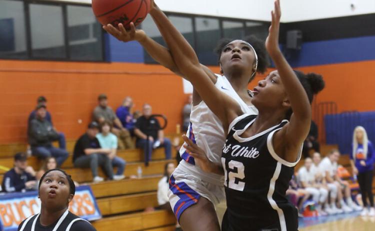Fort White forward Isreal Hart (12) blocks a layup attempt from Branford’s Zjamyah Wilson during Thursday night’s 56-26 Indians win at LeNelle Phillips Morgan Gym. (PAUL BUCHANON/Special to the Reporter)