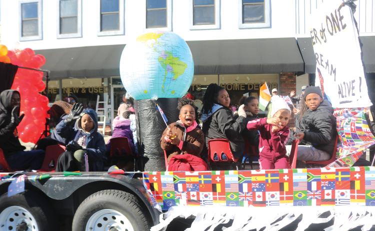 Children on the New Dayspring Missionary Baptist Church float hold flags representing various nations during the Dr. Martin Luther King Jr. parade on Jan. 20, 2020. (FILE)