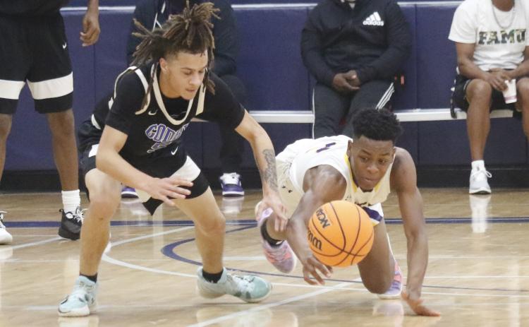 Columbia guard Jerome Carter dives for a loose ball against Godby during the Hitchcock’s Challenge at Legacy Park on Dec. 30 in Alachua. (JORDAN KROEGER/Lake City Reporter).