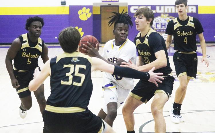 Columbia guard Isaac Broxey drives to the basket as Buchholz forwards Anthony Wilkie (20) and Palmer Walton (35) defend during Tuesday’s District 3-6A quarterfinal. (JORDAN KROEGER/Lake City Reporter)