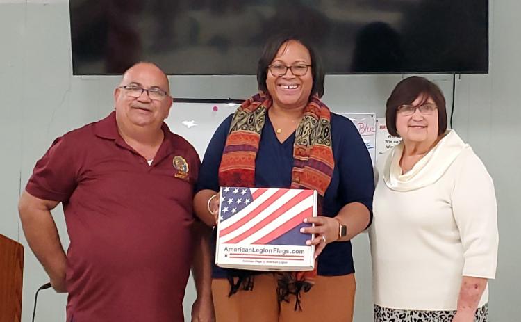 Columbia County Schools Assistant Superintendent Hope Jernigan (center) was presented with new American flags for district schools by American Legion Post Commander Rick Cabrera (left) and Irma Wehrli, Auxiliary Board member. (COURTESY)