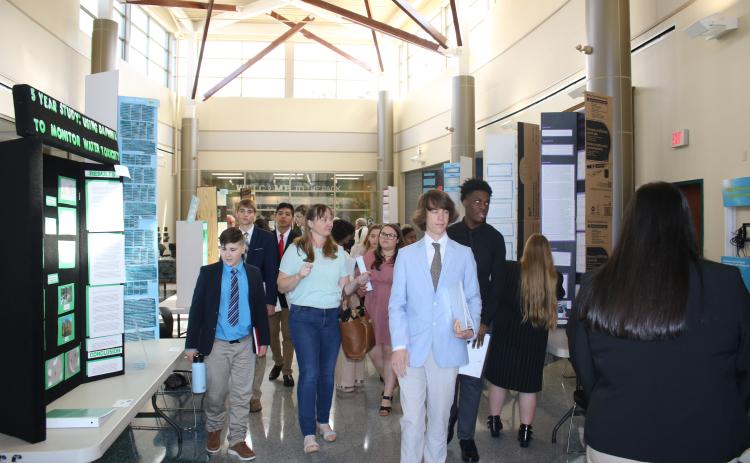 Students make their way through a hallway showcasing different science fair projects Thursday afternoon at Florida Gateway College. Students had a chance to look at each other’s projects as judges deliberated their decision. (TONY BRITT/Lake City Reporter)