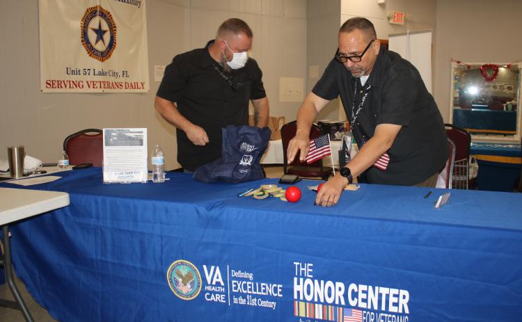 A pair of VA associates set up a table at American Legion Post No. 57 ahead of Thursday’s event. (TONY BRITT/Lake City Reporter)