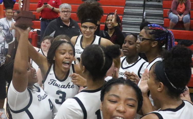 The Fort White girls basketball team hoists the District 6-1A Championship trophy in the air as it celebrates the program’s first district title Friday night. (MORGAN MCMULLEN/Lake City Reporter)