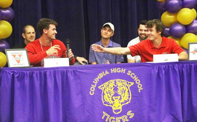 Columbia golfer Zach Shaw (right) reaches for the microphone from teammate Ty Folsom as the two share a laugh during Thursday’s signing ceremony. (MORGAN MCMULLEN/Lake City Reporter)