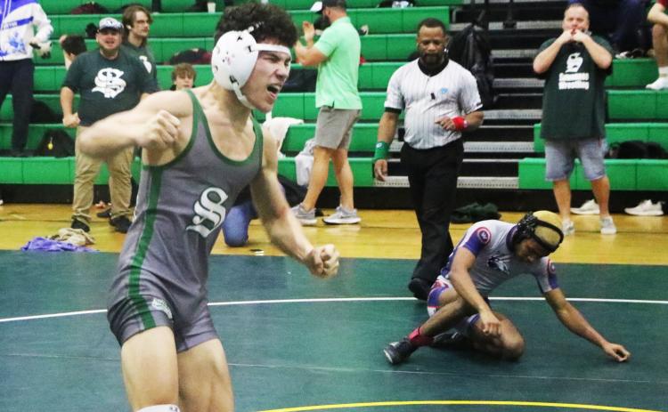 Suwannee wrestler Topher Pearson celebrates after winning the District 2-1A title in he 106 class on Friday. (MORGAN MCMULLEN/Lake City Reporter)