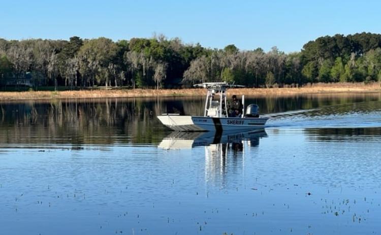A Suwannee County Sheriff’s Department watercraft searches for the remains of Paul Gibson. Patrols found the 35-year-old’s body in Peacock Lake on Monday. (COURTESY)