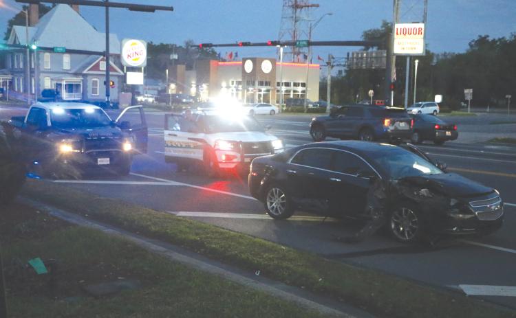 Columbia County Sheriff’s deputies block traffic in one lane heading westbound on U.S. Highway 90 near NW Main Blvd. in front of a wrecked Chevy Malibu on Wednesday night. (MORGAN MCMULLEN/Lake City Reporter)