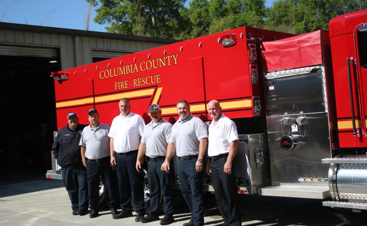 Columbia County Fire Rescue employees Cody Bertram (from left), Arness Thomas, Assistant Chief Lance Hill, Collin Redish, Brian King and Chief Jeff Crawford pose in front of the department’s new tanker trunk. (TONY BRITT/Lake City Reporter)