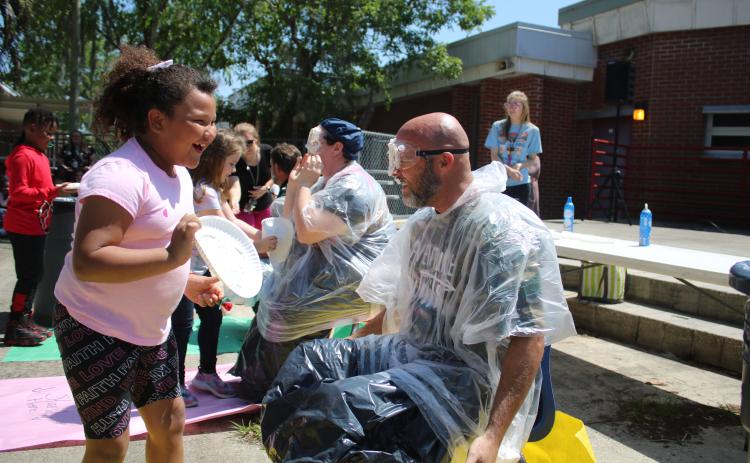 Melrose Park Elementary School student Aylin Alvarez (left) reacts after smearing Assistant Principal Stephen Smithy with a whipped cream pie. (TONY BRITT/Lake City Reporter)