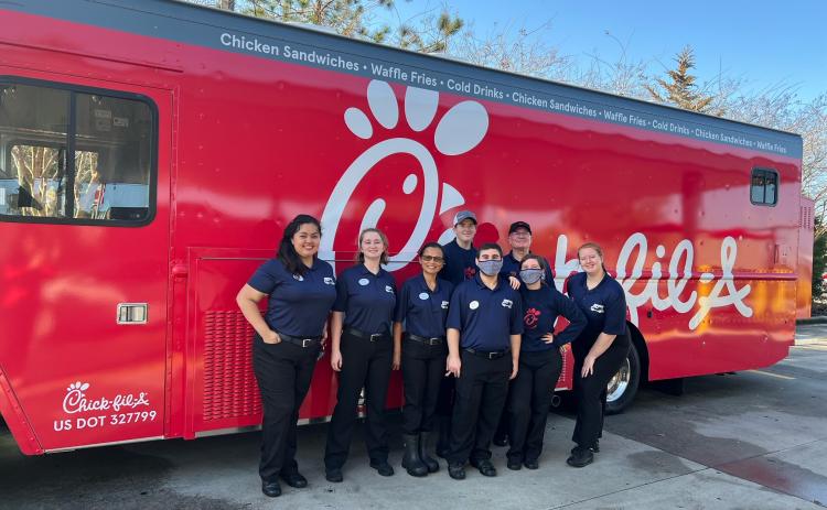 Chick-fil-A associates pose in front of the new food truck that will be serving up fast food treats. (COURTESY)