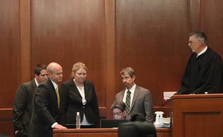 Representatives for both the prosecution and defense — including State Attorney John Durrett (second from left) and defense attorneys Allison Miller (third from left) and Nathan Marshburn (second from right) — and Judge Paul Bryan (right) gather around the court’s stenographer to review a piece of testimony Thursday afternoon at the Columbia County Courthouse. (MORGAN MCMULLEN/Lake City Reporter)